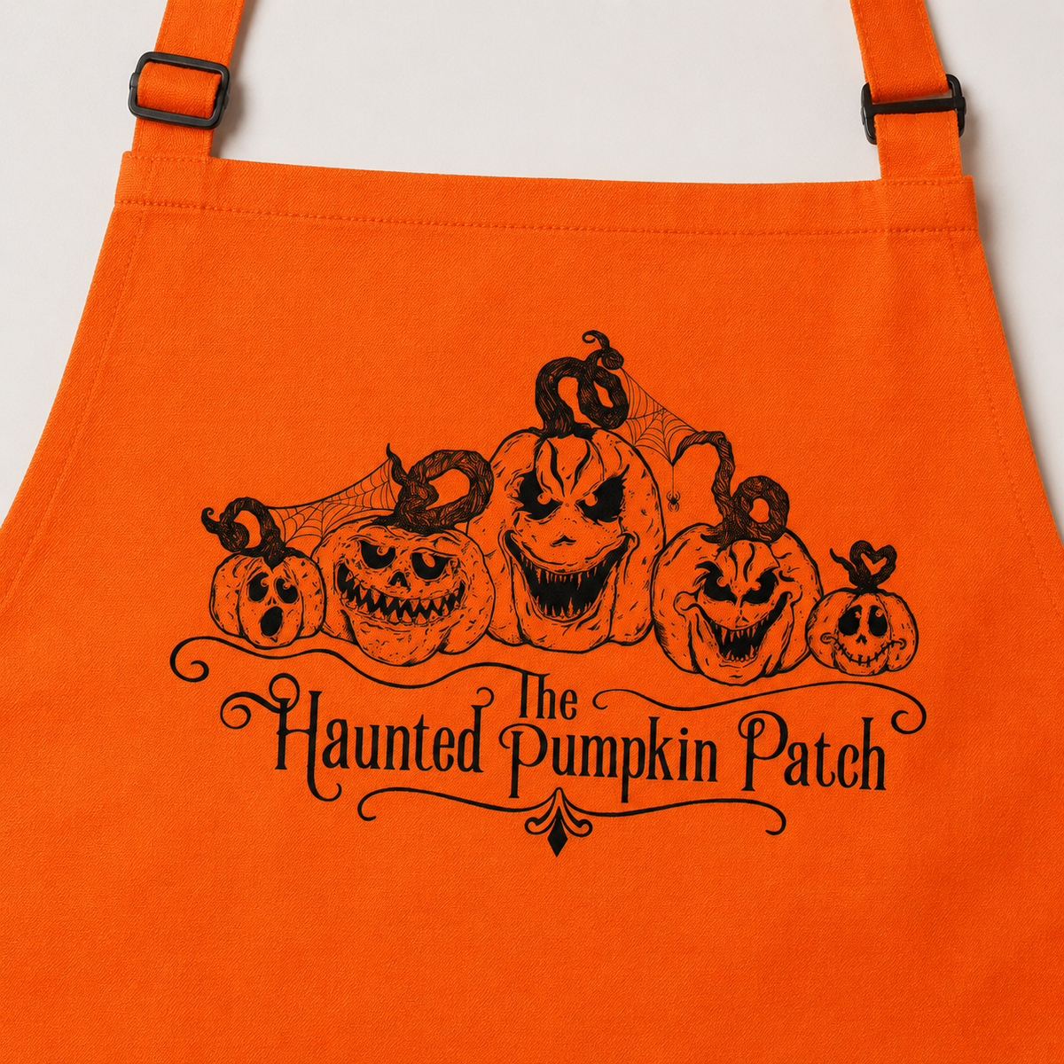 Close detail of The Haunted Pumpkin Patch artwork on orange apron